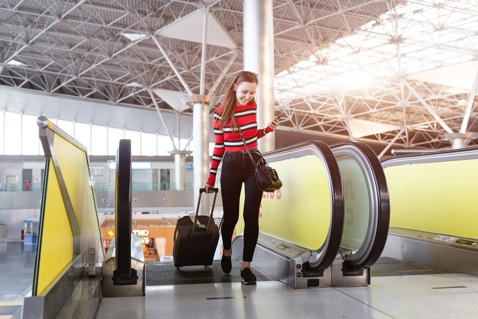 Jong vrouw komt van roltrap af