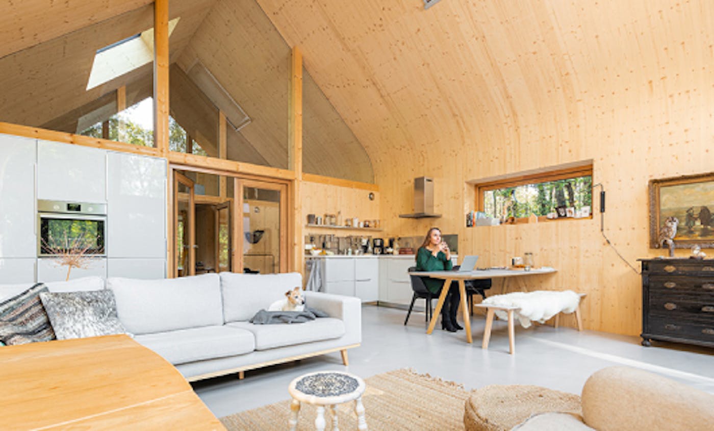 Tanja zit aan tafel in haar houten boshuis