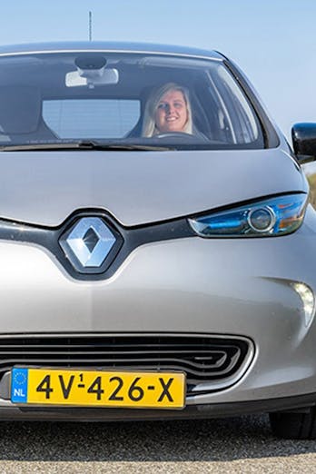 een vrouw in een grijze elektrische Renault ZOE