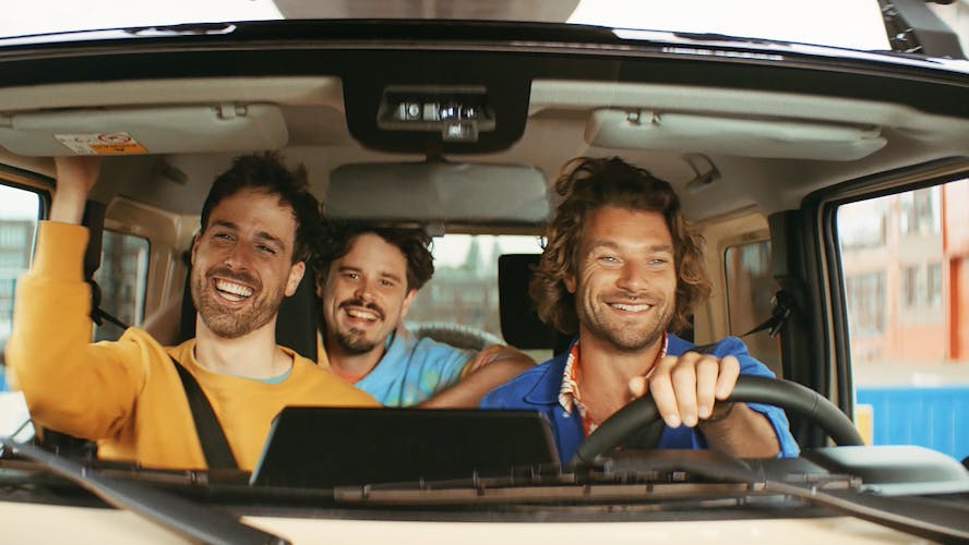 lachende vrienden in de auto met een groene kaart