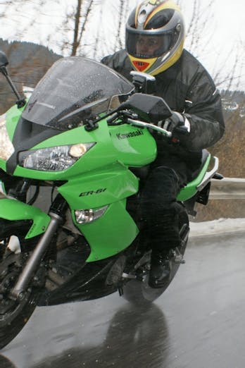 Motorrijder op de weg met sneeuw langs de kant