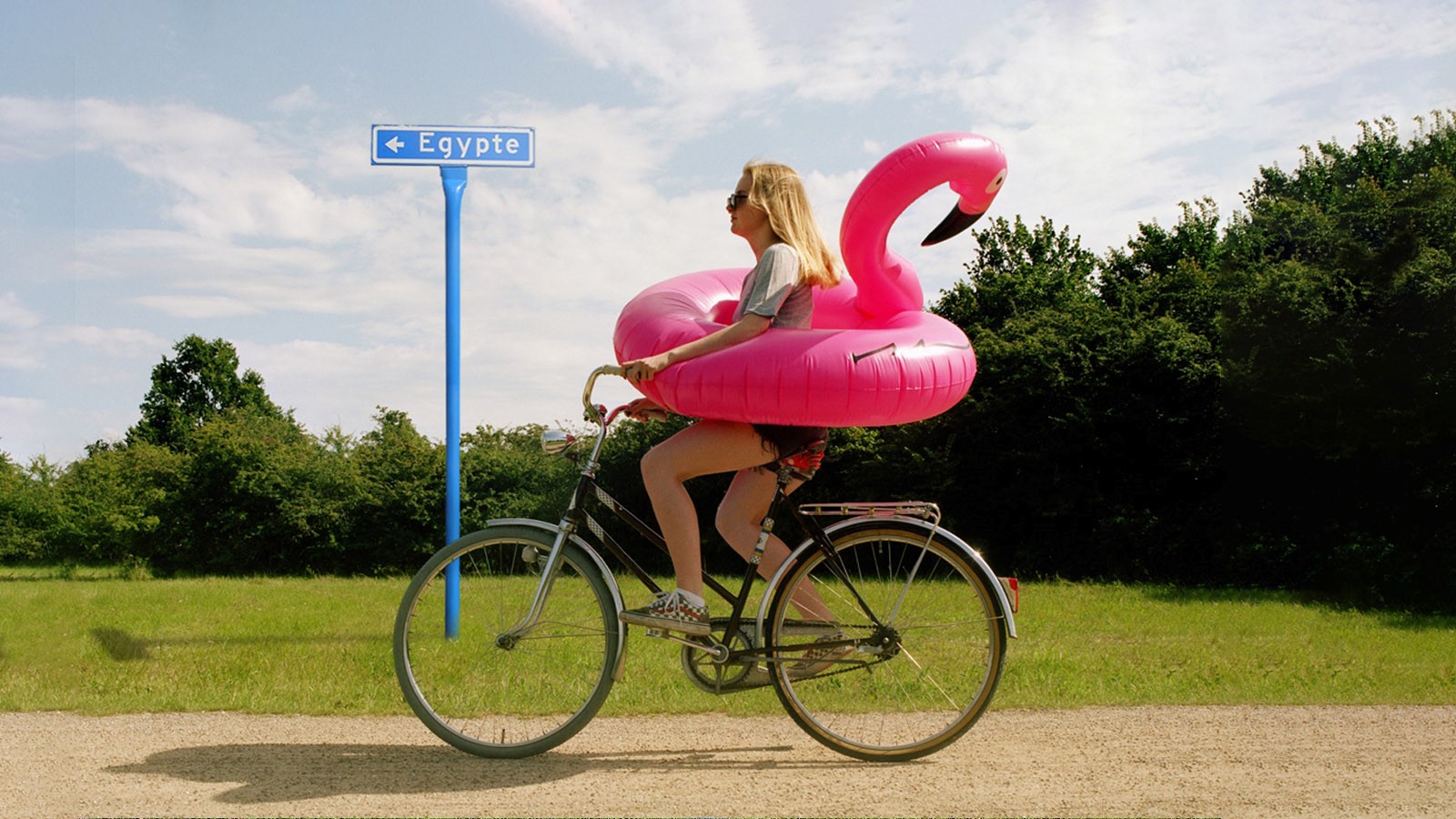 Vrouw op de fiets met roze zwemband