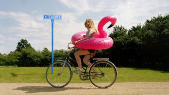 Vrouw op de fiets met roze zwemband