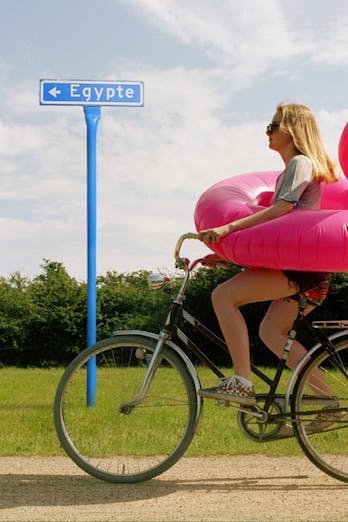 Vrouw op de fiets met roze zwemband