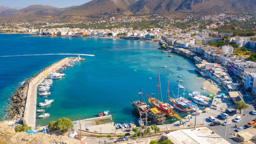 Bovenaanzicht van de haven van Kreta met een stralend zonnetje en azuurblauw water
