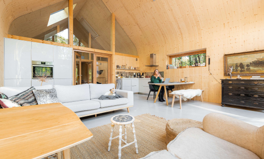 Afbeelding van inrichting houten huis in de natuur.