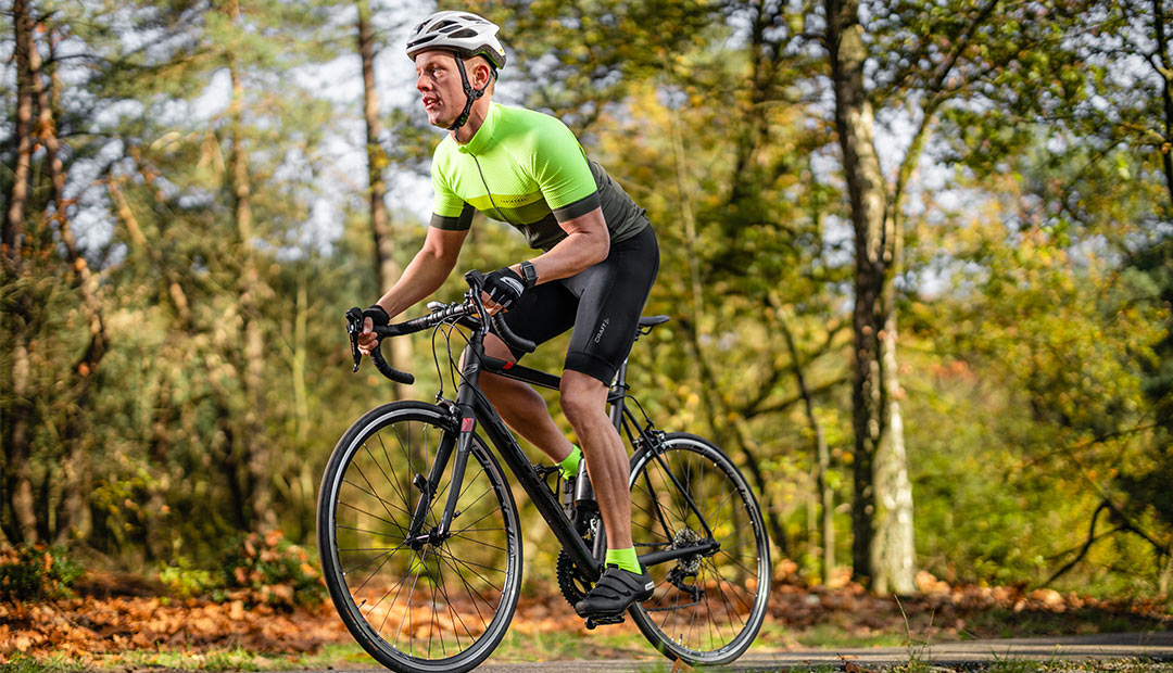 Robert fietst op zijn racefiets door het bos