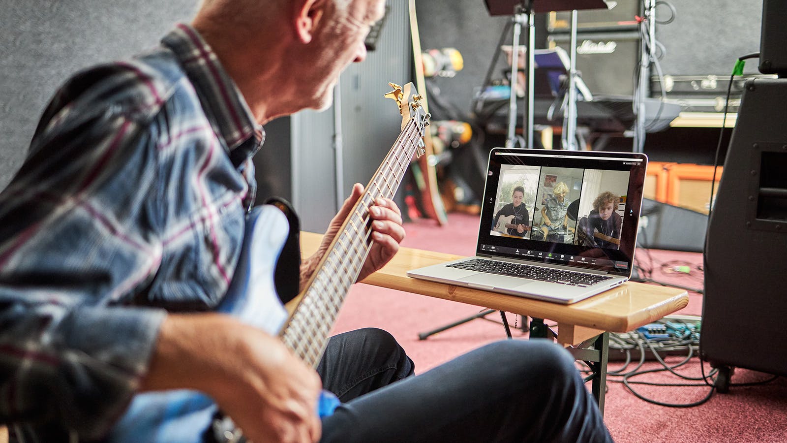 Opa Jaap speelt gitaar terwijl zijn kleinkinderen via de laptop in beeld zijn