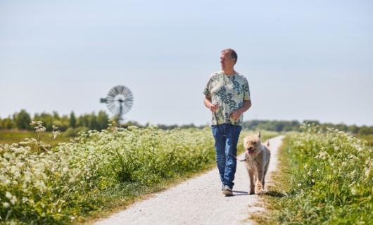 Leo loopt met hond door het weiland
