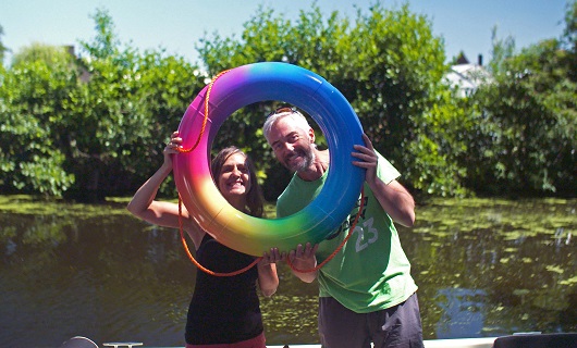 Nonie en Eric achter hun regenboogkleurige reddingsboei