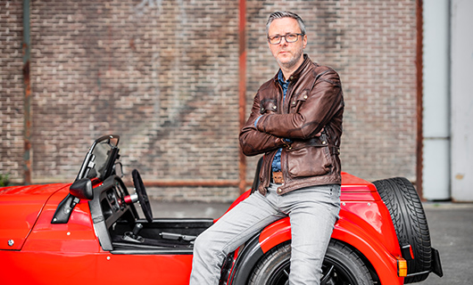 Martijn leunt tegen zijn cabrio