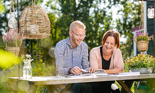 Daan en Annelies aan de tuintafel bij hun tiny house
