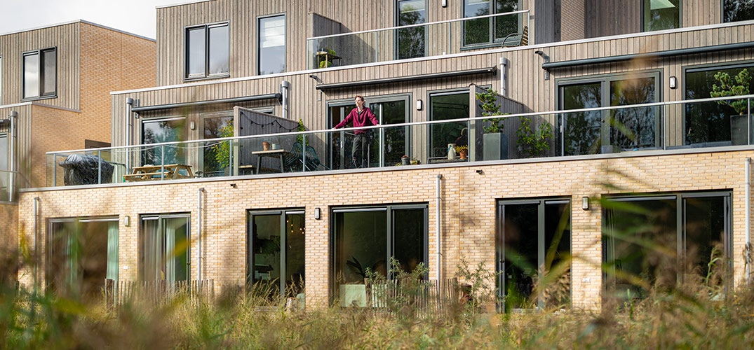 Mart staat op het balkon van zijn nieuwbouwwoning