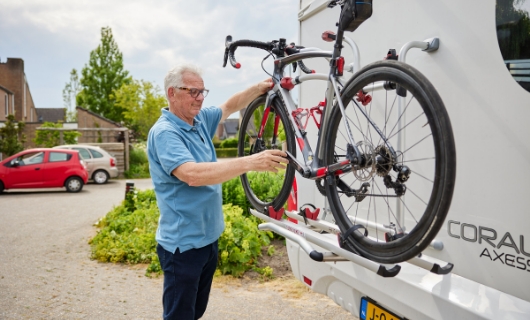 Evert plaatst zijn racefiets op fietsendrager van de caravan