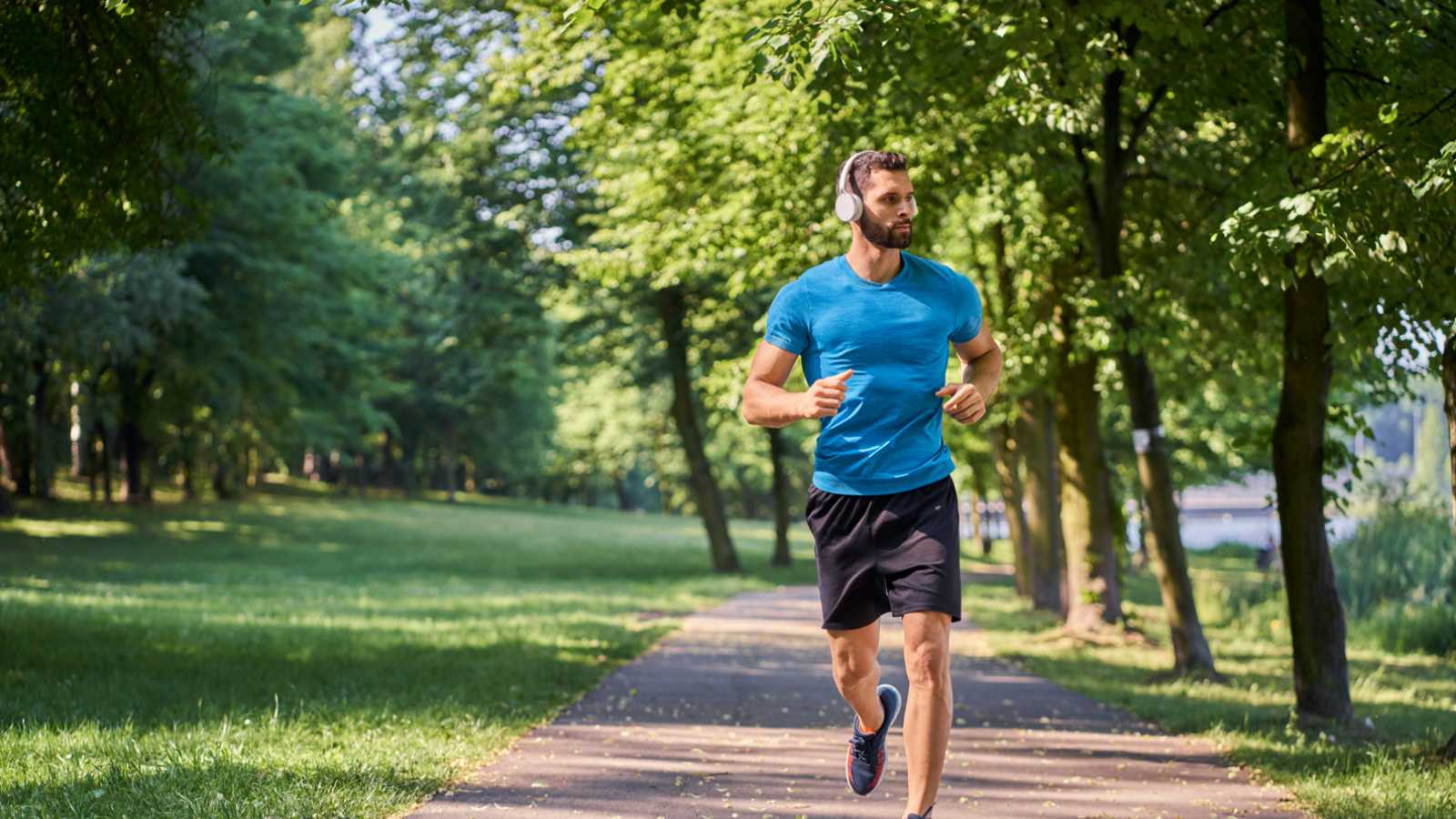 een hardloper rent met koptelefoon op door het park