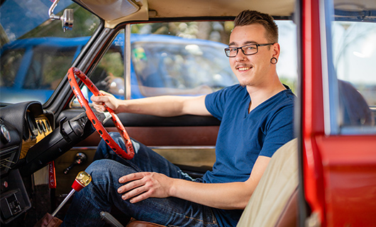 Martijn achter het stuur van zijn Lada