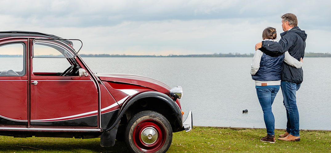 Pieter staat met zijn vrouw naast hun Lelijke Eend
