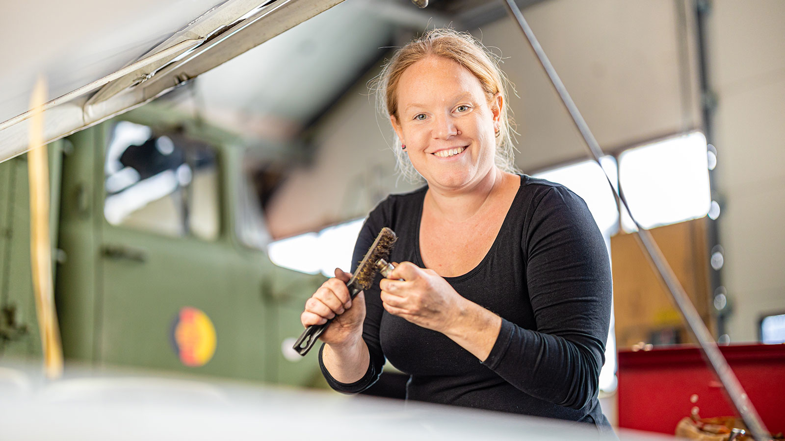 Jolien poetst een onderdeel van haar oldtimer