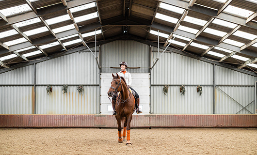 Esra rijdt op haar paard in de binnenbak