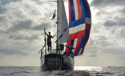 Meneer zwaait op een zeilboot op zee