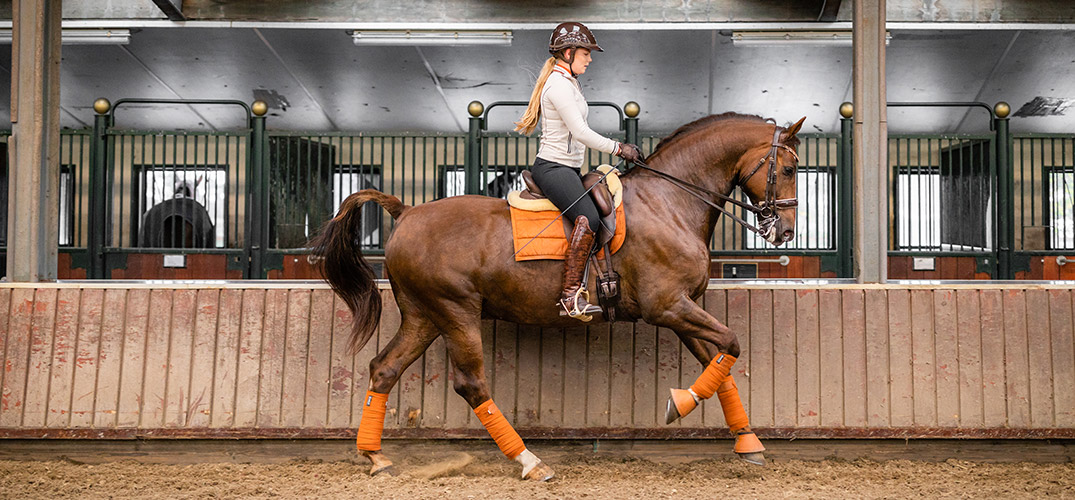 Esra rijdt op haar paard in de binnenbak