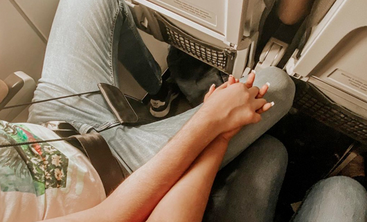 Met ineen verstrengelde handen in het vliegtuig