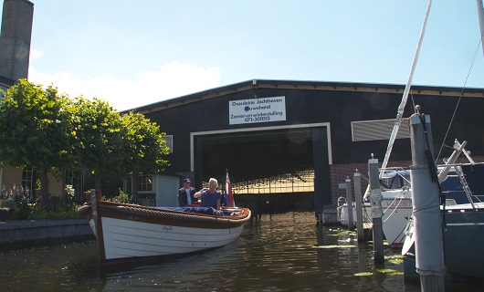 Een sloep wordt uit de loods gevaren
