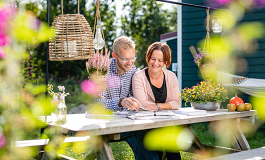 Daan en Annelies aan de tuintafel bij hun tiny house