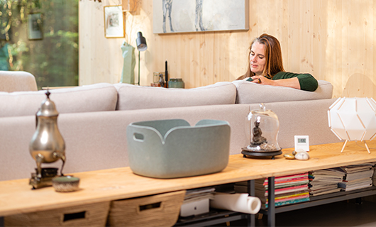 Tanja zit op de bank in haar boshuis