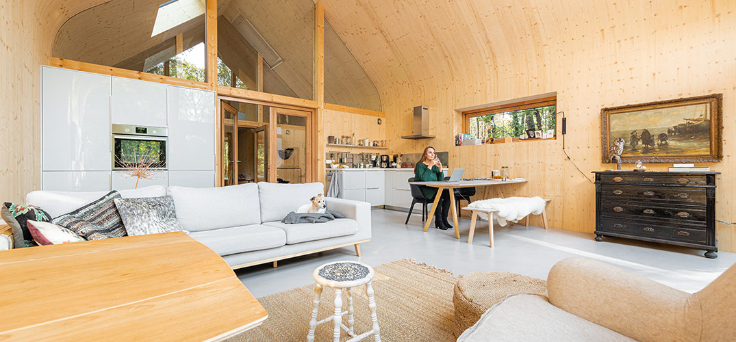Tanja zit aan tafel in haar houten boshuis