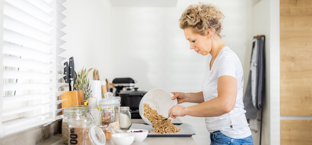 Grietje schept granola over naar een bord