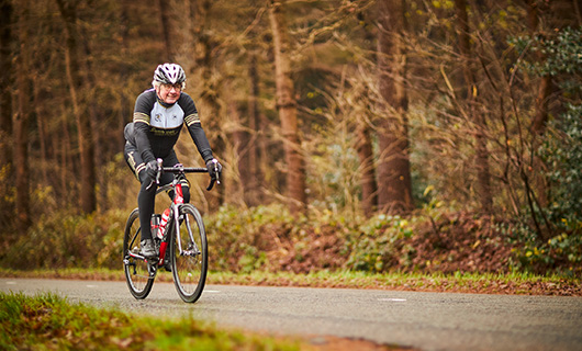 Evert fietst op de racefiets door de bossen
