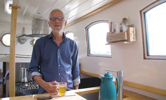 Eric staat in de kombuis van zijn zeilboot