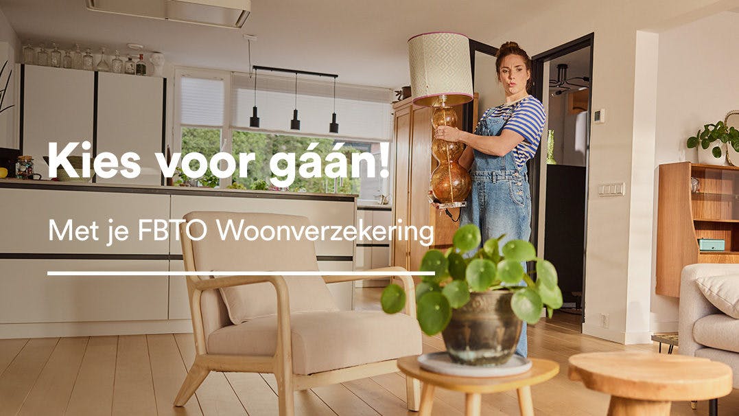 Een vrouw geeft een staande lamp een plek in haar kamer. Kies voor gaan! Met je FBTO woonverzekering.