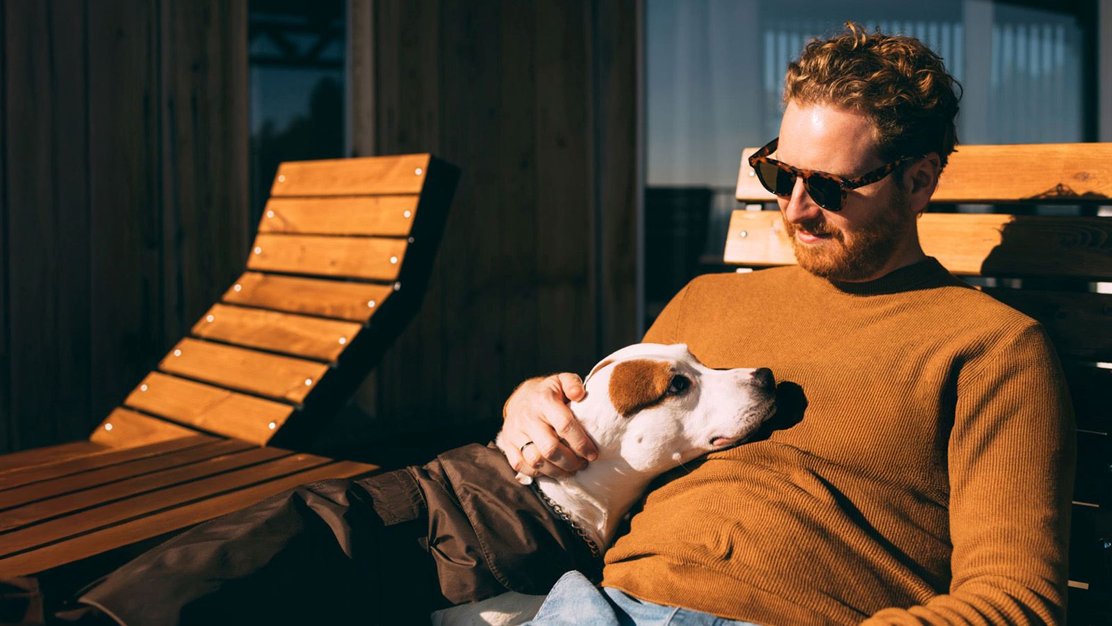 Man met hond liggen lekker in het zonnetje op ligbed