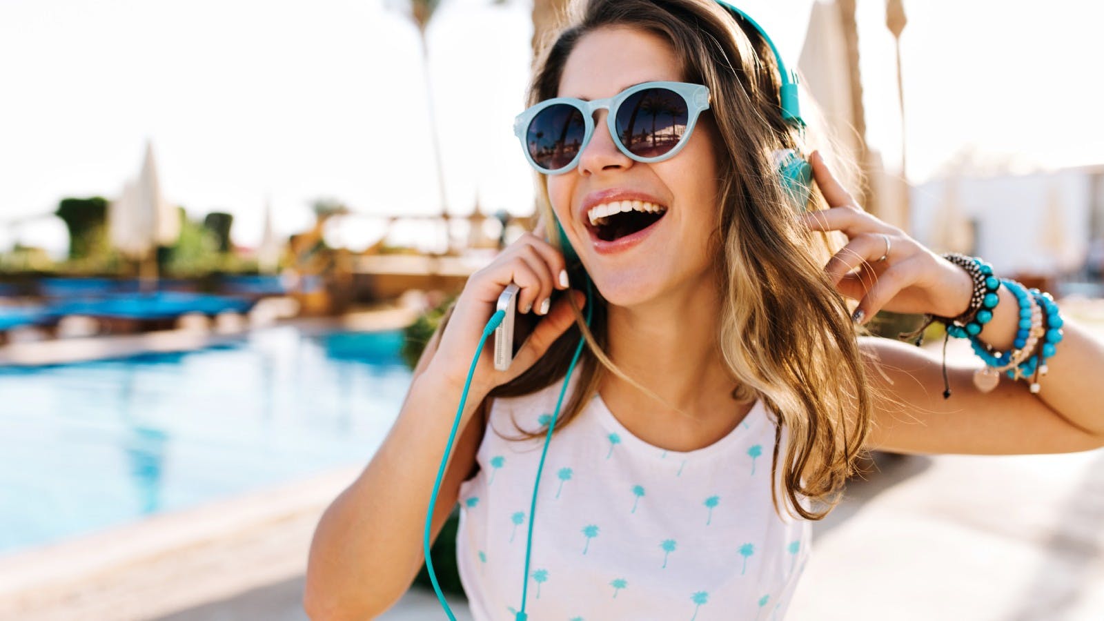 vrolijke jonge vrouw heeft een koptelefoon op en luistert naar muziek van haar telefoon