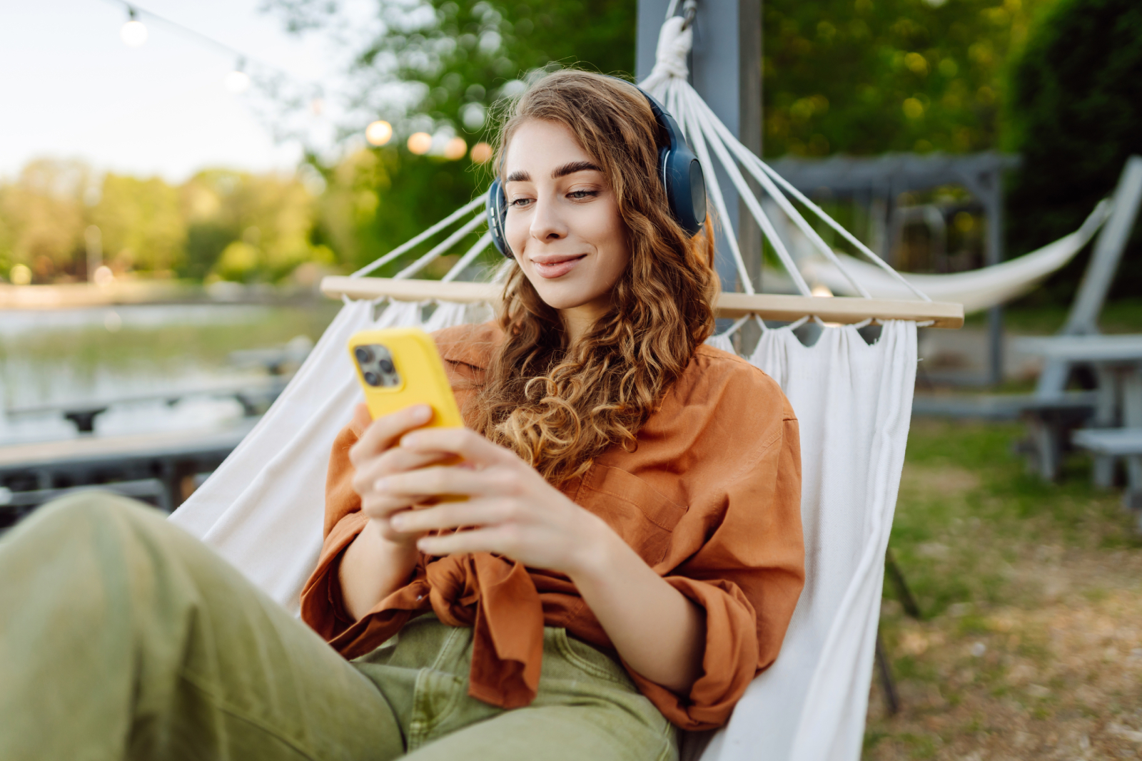 Vrouw in hangmat met mobiel in haar handen