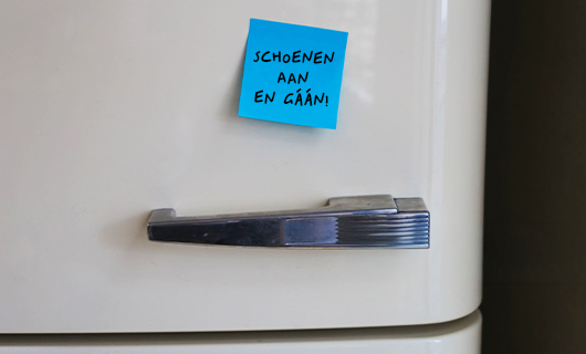 Witte vintage koelkast met een lichtblauwe post-it met de tekst ‘Schoenen aan en gáán!’