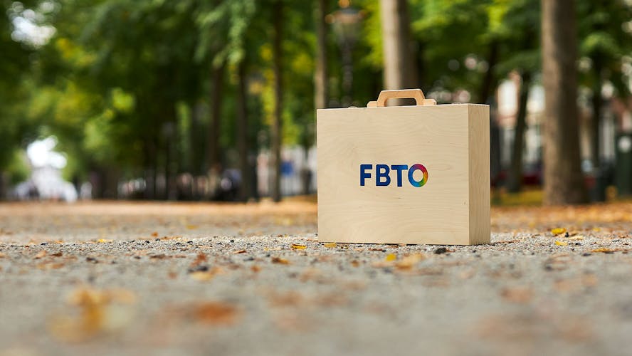 Op een straat met bladeren staat een FBTO koffer