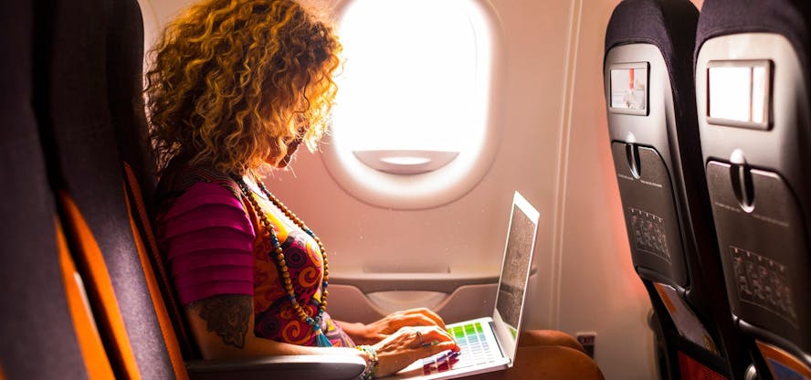 Vrouw in het vliegtuig met laptop
